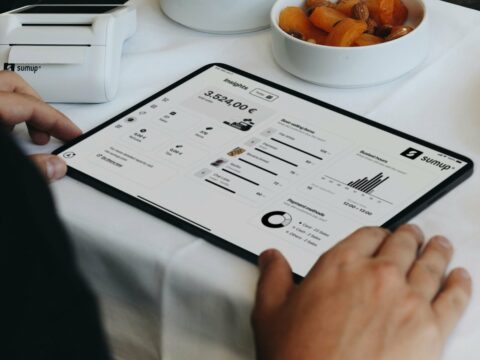 A person sitting at a table with a tablet
